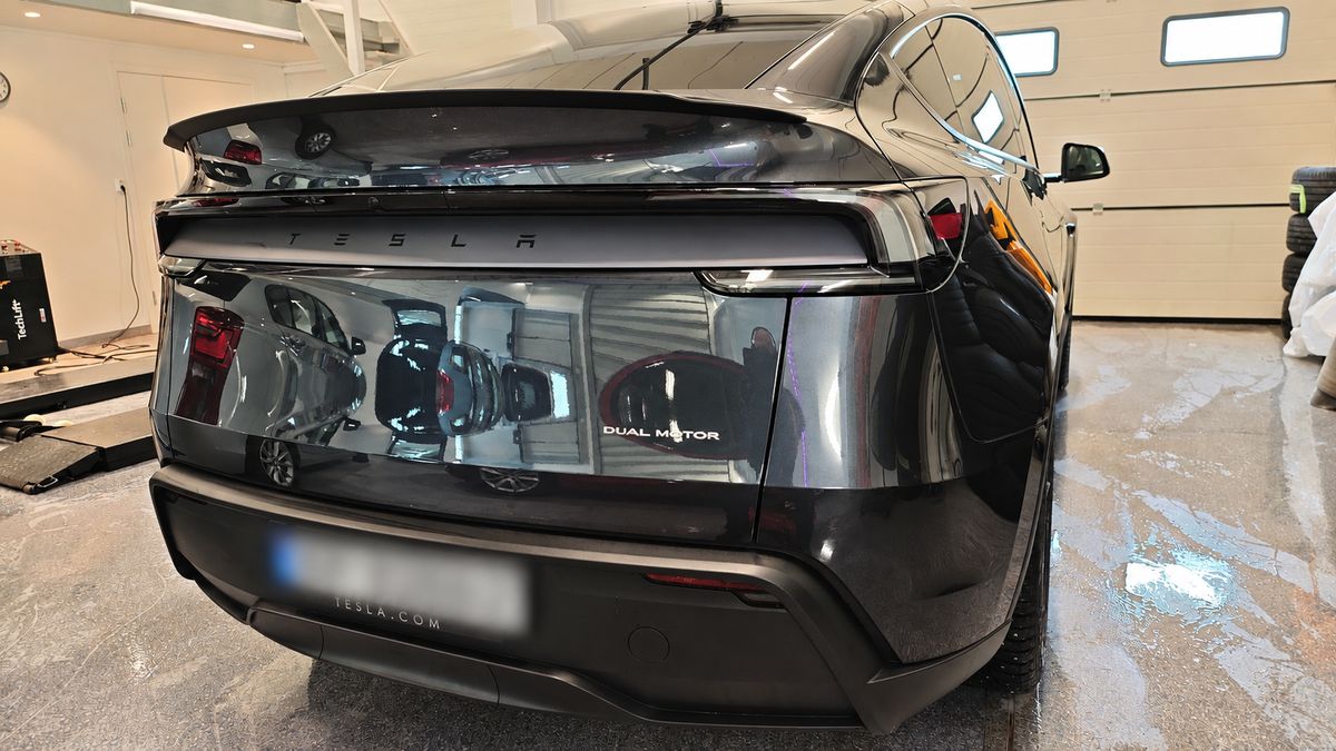 Sort Tesla Model Y sett bakfra med dyp glans etter vask
